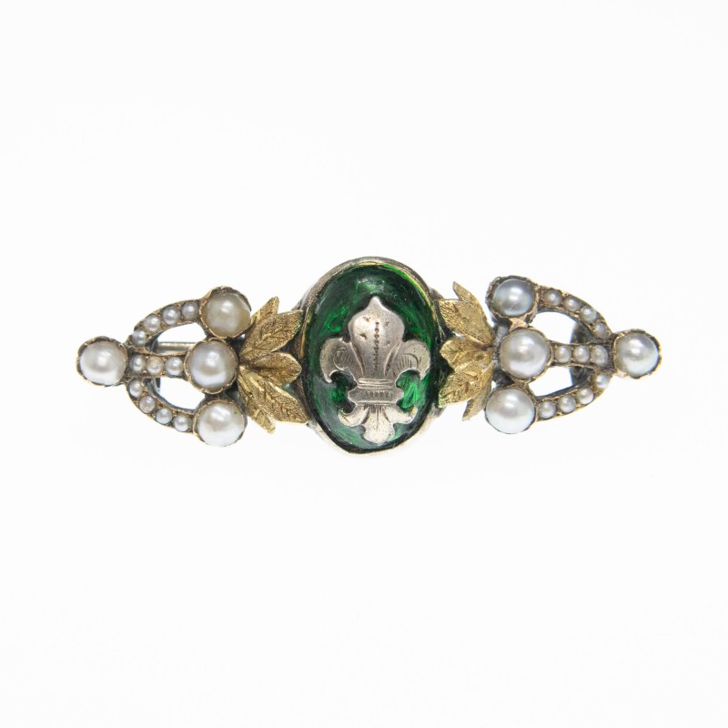 Broche en argent à la fleur de Lys sur fond émaillé vert, décoré de perles sur monture et feuillage en or.