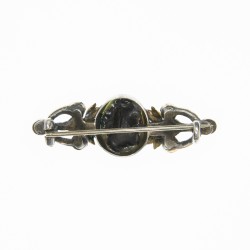 Broche en argent à la fleur de Lys sur fond émaillé vert, décoré de perles sur monture et feuillage en or.