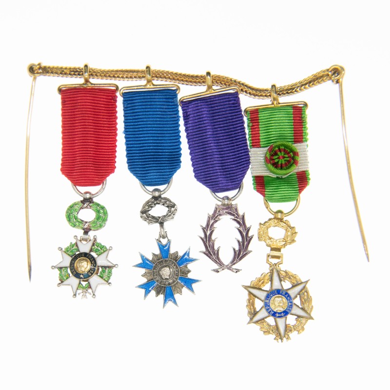 Chainette à épingle composée de 4 médailles miniatures :