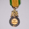 Military medal in miniature.