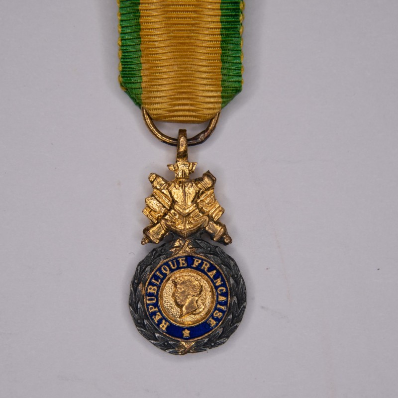 Military medal in miniature.