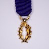 Médaille miniature d'officier des palmes académiques en or, sertie d’un diamant.