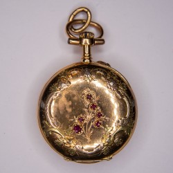 Montre de col en or avec rubis. A decors de feuillages et fleurettes.