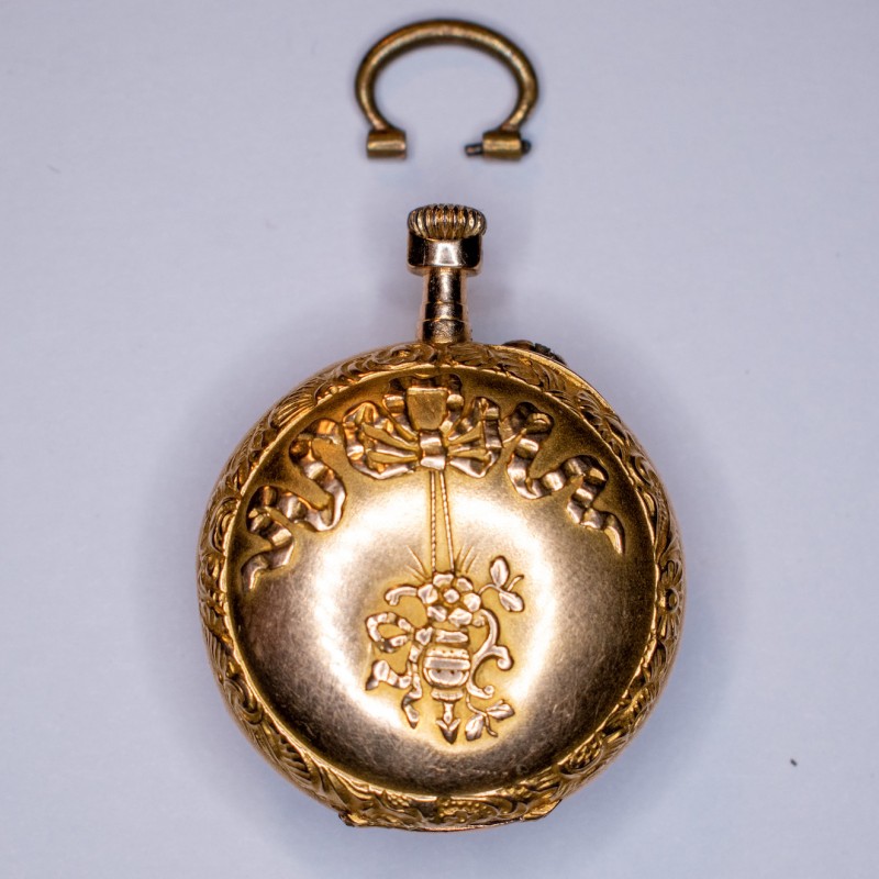 Montre de col en or jaune 18k, cadran à fond blanc, chiffre romains pour les heures, aiguilles filigranées. Montre de col en or jaune 18k, cadran à fond blanc, chiffre romains pour les heures, aiguilles filigranées.