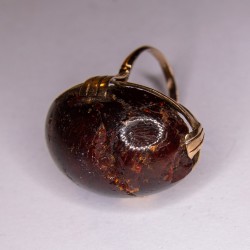 Gold-rimmed ring adorned with an amber cabochon (accidents).