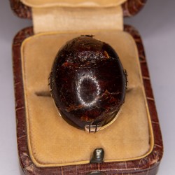 Gold-rimmed ring adorned with an amber cabochon (accidents).