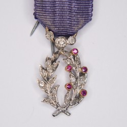 Belle médaille de l'ordre des palmes académiques en or blanc et jaune, ornée de diamant et rubis.